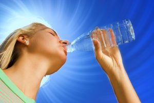 Beautiful blond girl drinking water